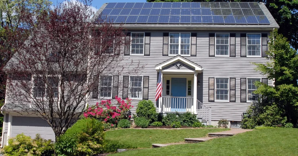 Rooftop solar panels on a house that a neighbor tree could shade
