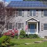 Rooftop solar panels on a house that a neighbor tree could shade
